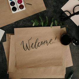 Brown craft paper with calligraphy writing that says "Welcome"