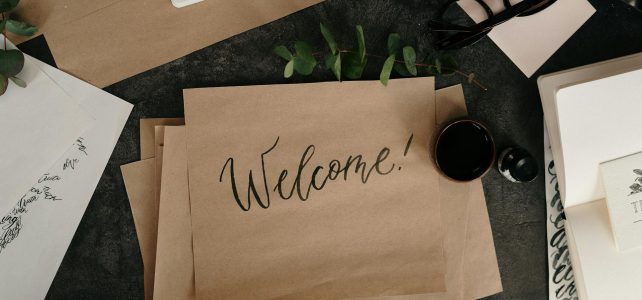Brown craft paper with calligraphy writing that says "Welcome"